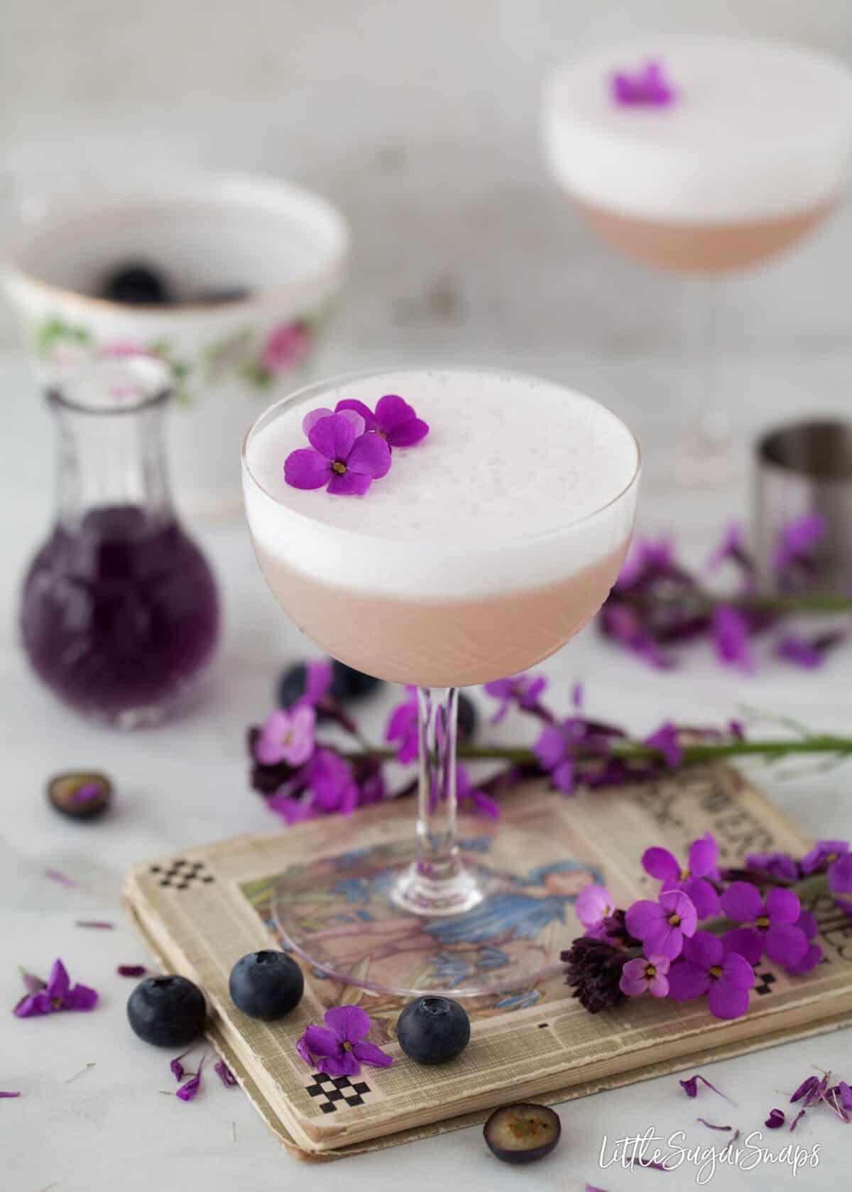 Violet Blueberry Gin Sour decorated with flowers