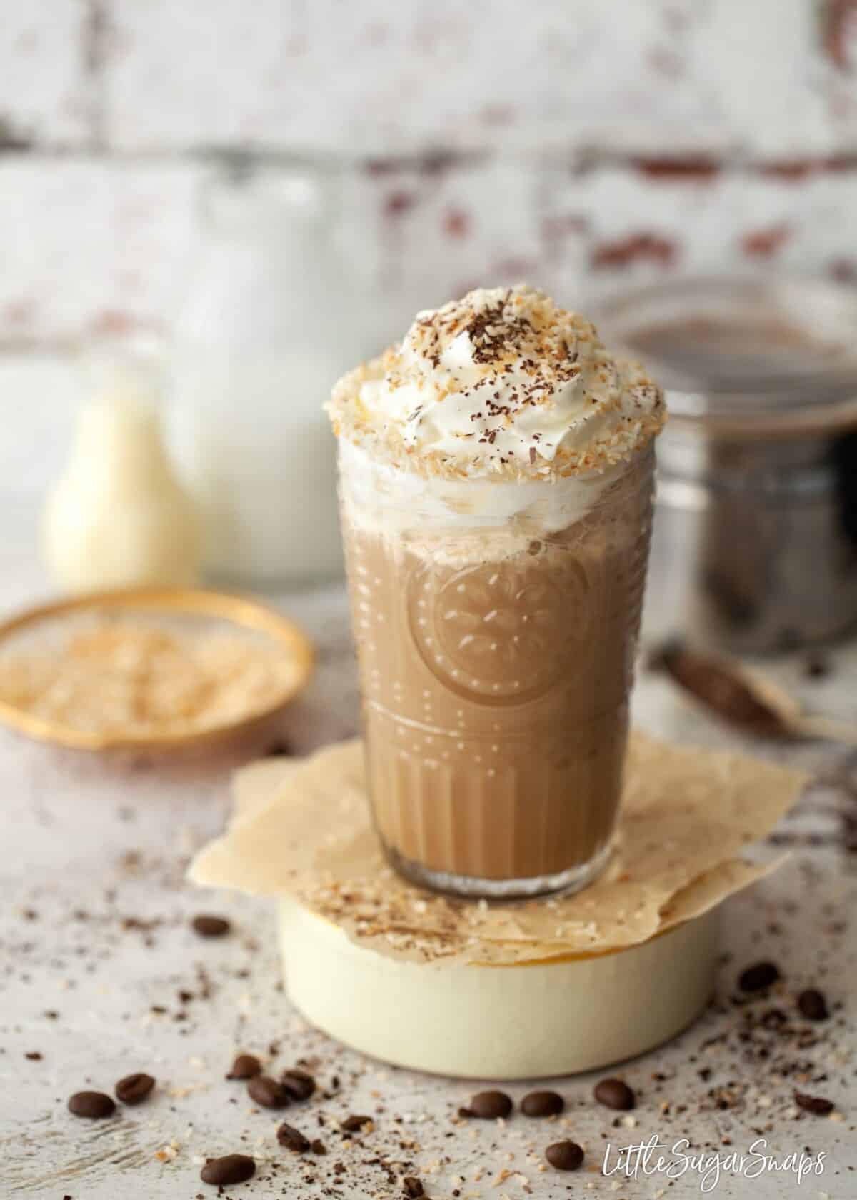 A glass of coconut iced coffee with whipped cream.