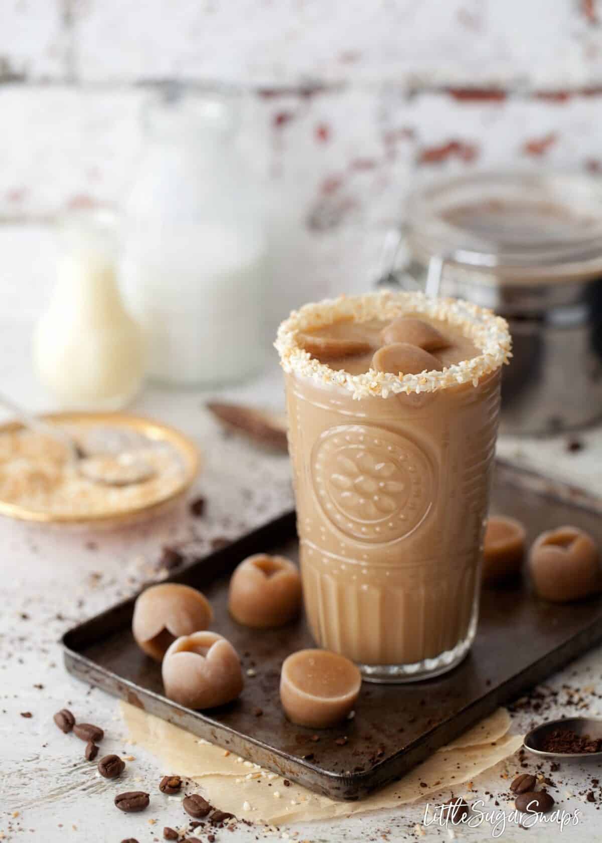 Ice coffee garnished with toasted coconut and coffee ice cubes.