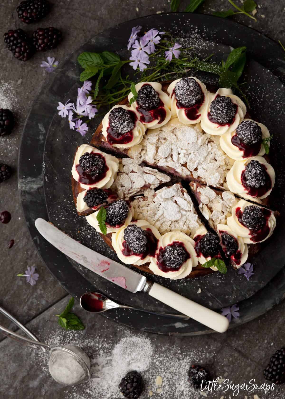 Overhead of baked cheesecake with blackberry coulis cut into slices