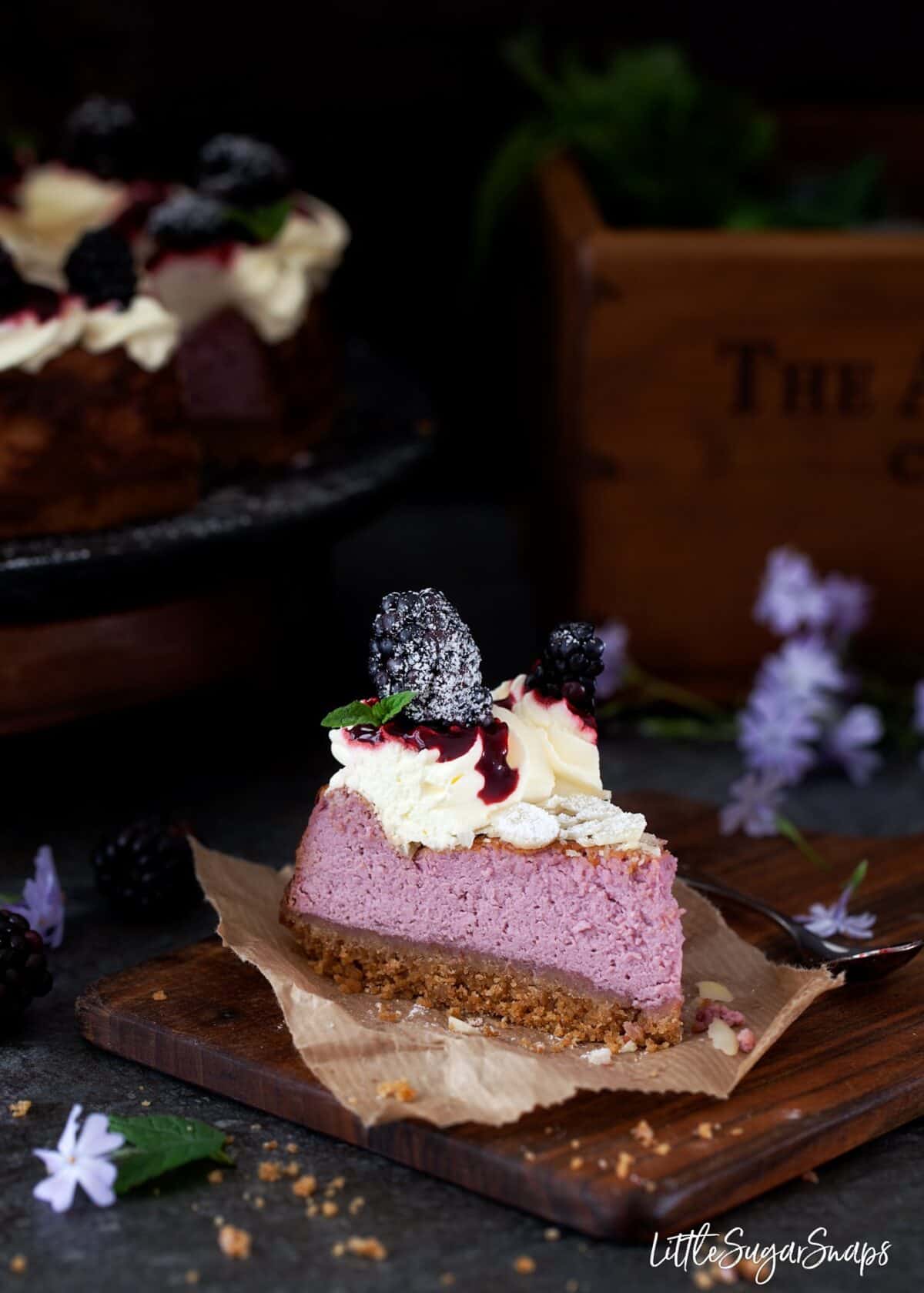 A slice of cheesecake on a wooden board