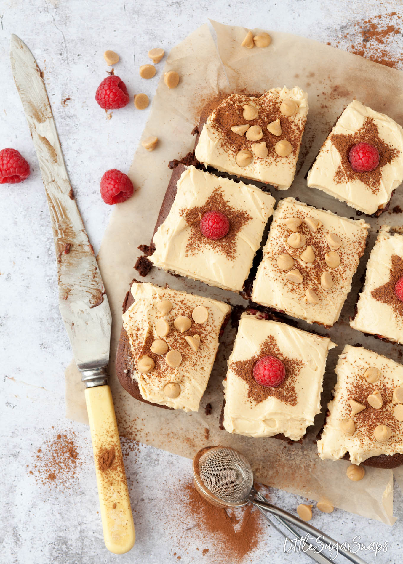 Squares of raspberry brownies with peanut butter frosting freshly cut.