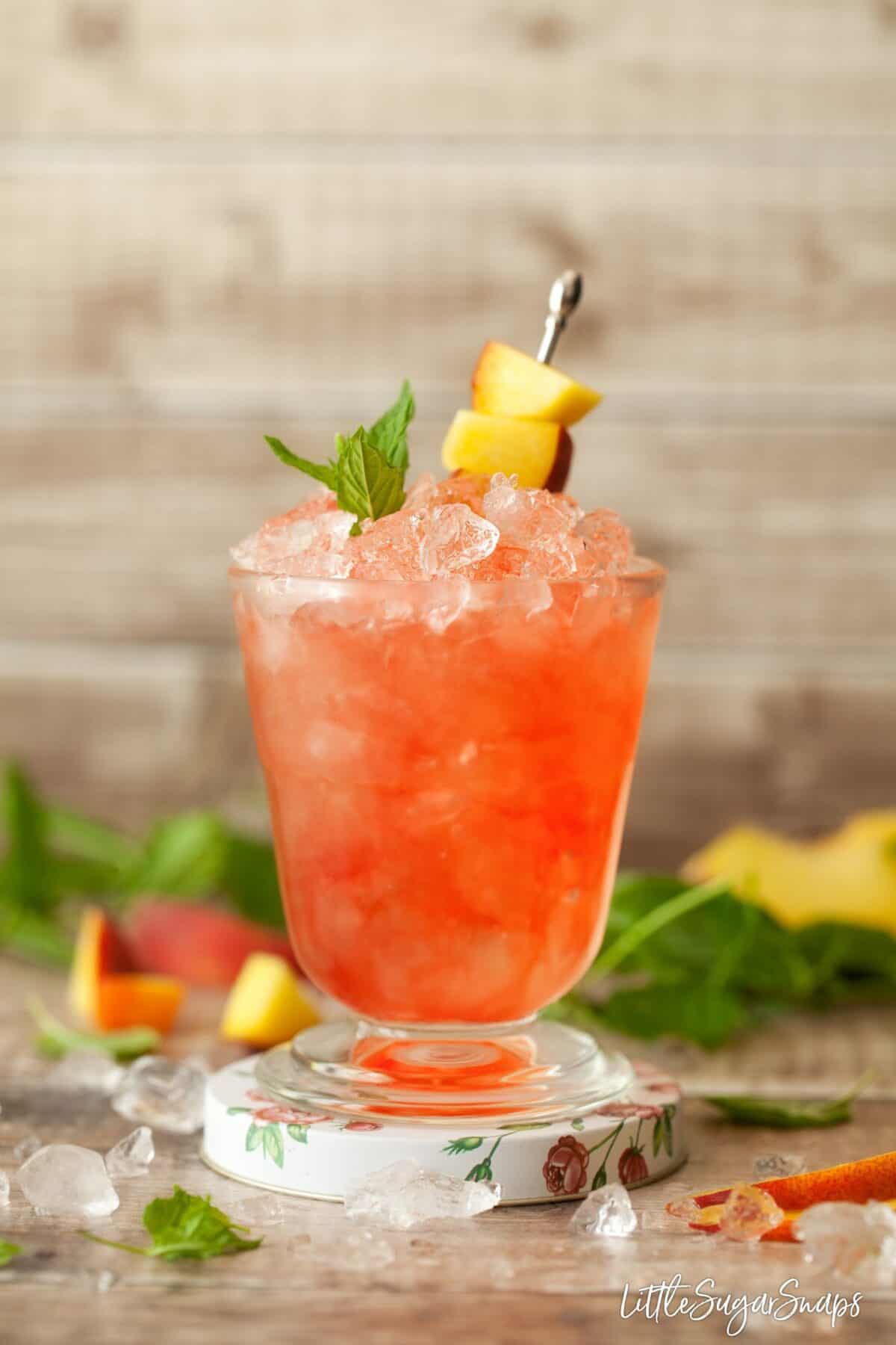 Close up of a raspberry peach bramble cocktail