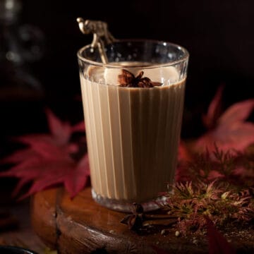 Glass of masala chai garnished with star anise