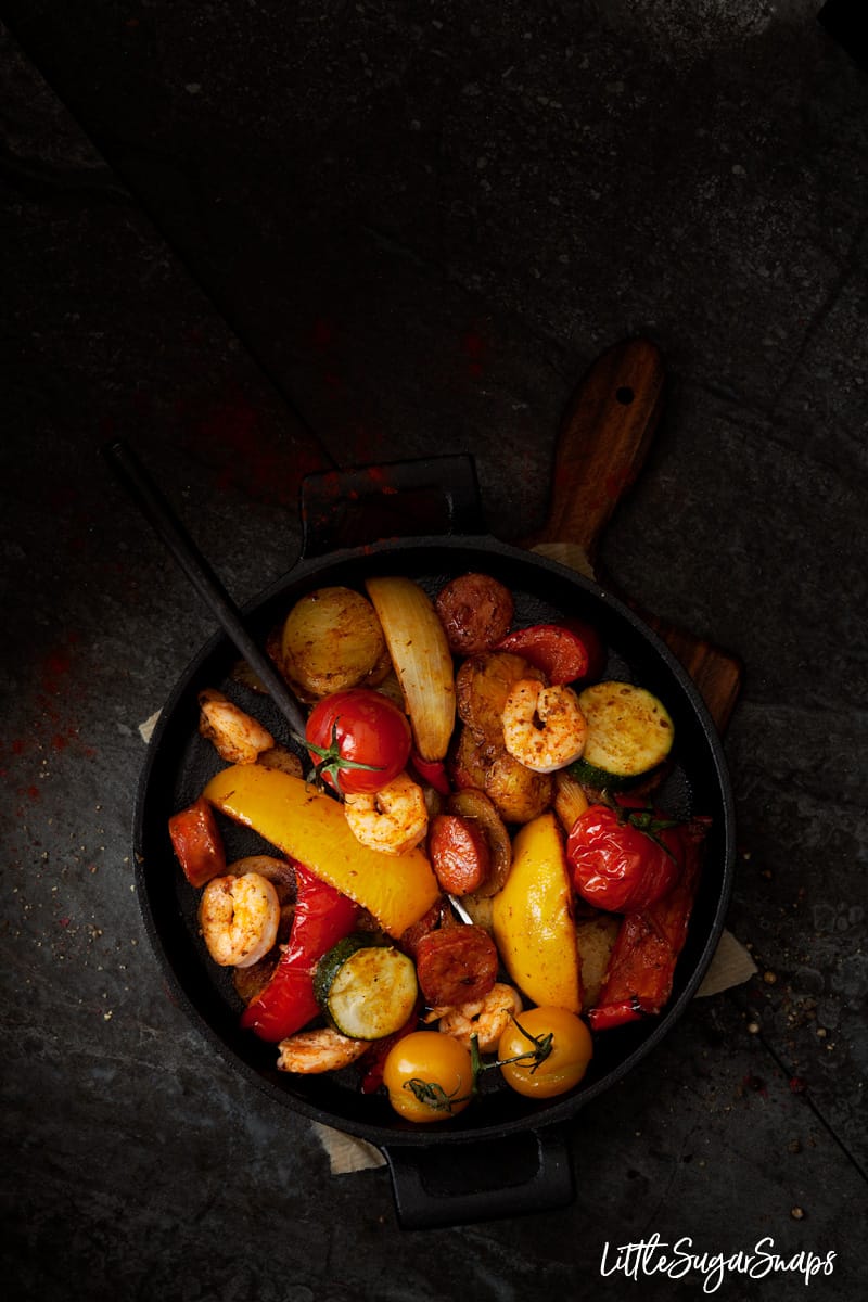 skillet chorizo and prawn dinner with onion, baby tomatoes, red and yellow peppers and courgette