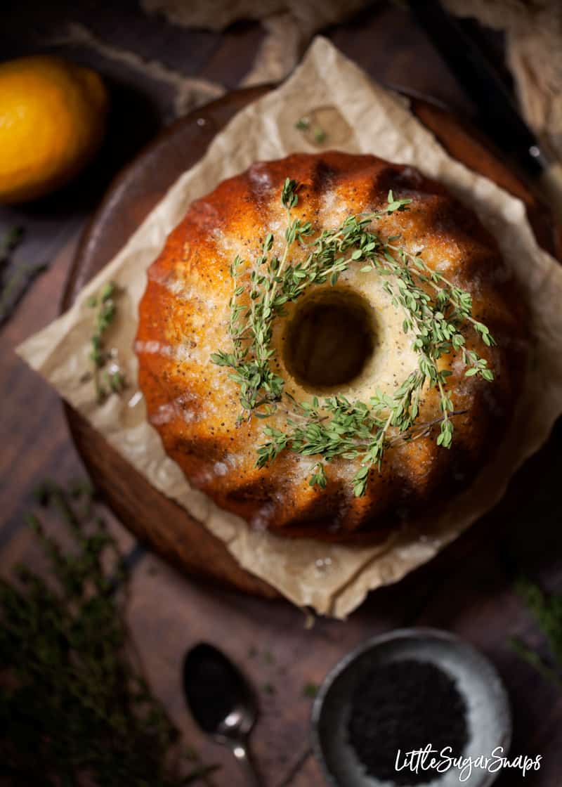 overhead view of lemon drizzle bundt cake topped with fresh thyme