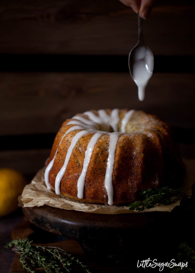 icing being spooned over a sponge cake