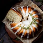 Overhead view of lemon bundt cake with poppyseeds. The cake has been sliced into and one slice is lying on it's side