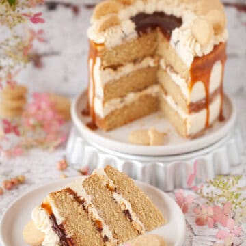 Millionaires Shortbread Cake with caramel and chocolate sauce with a slice cut out on a plate in front