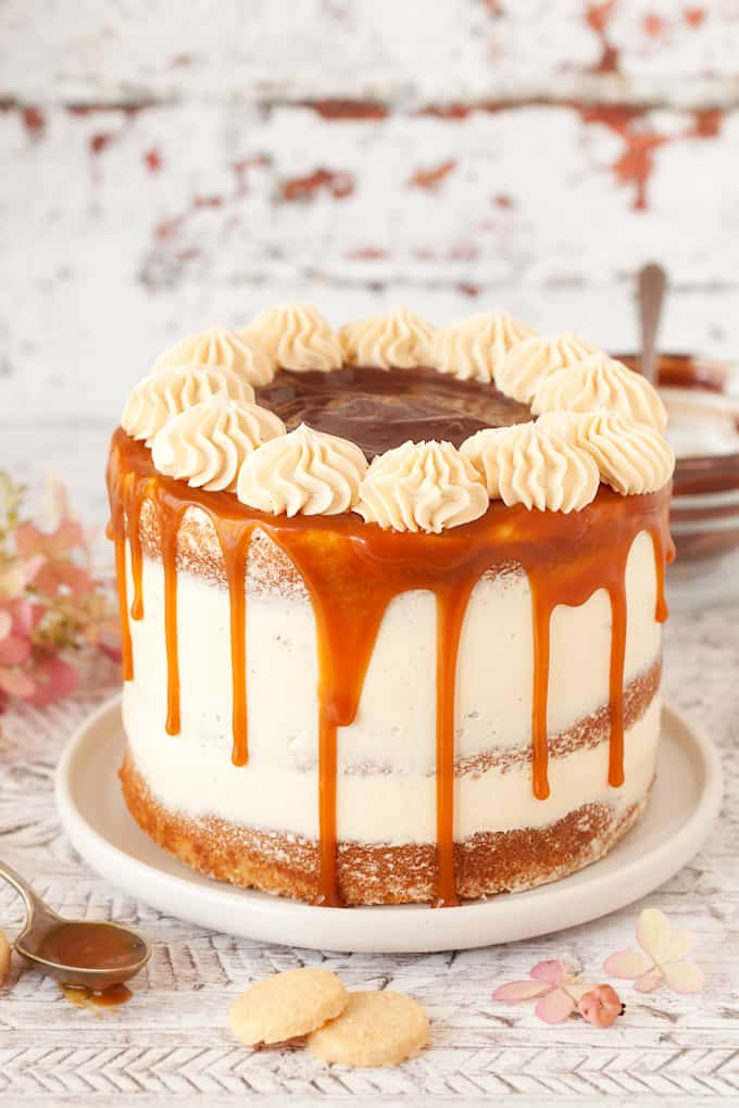 Rossettes of buttercream piped on top of a caramel drip cake