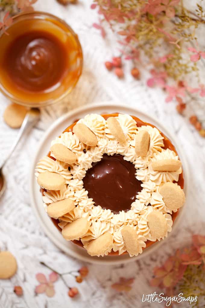 Overhead view of millionaire cake decorated with Italian buttercream, chocolate ganache, mini cookies and caramel sauce.