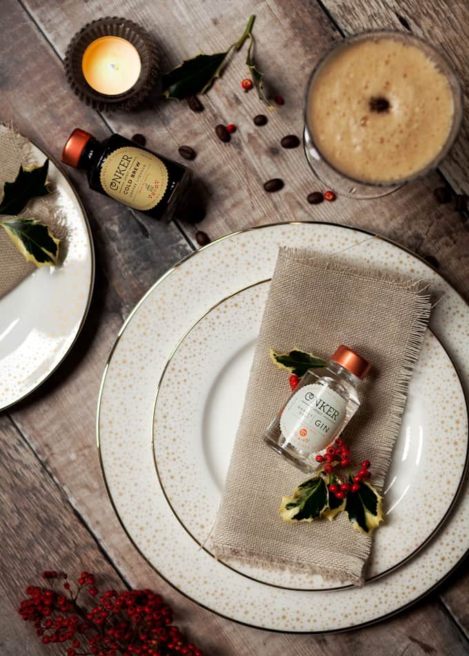 Mini bottle of gin on a Christmas themed place setting. 