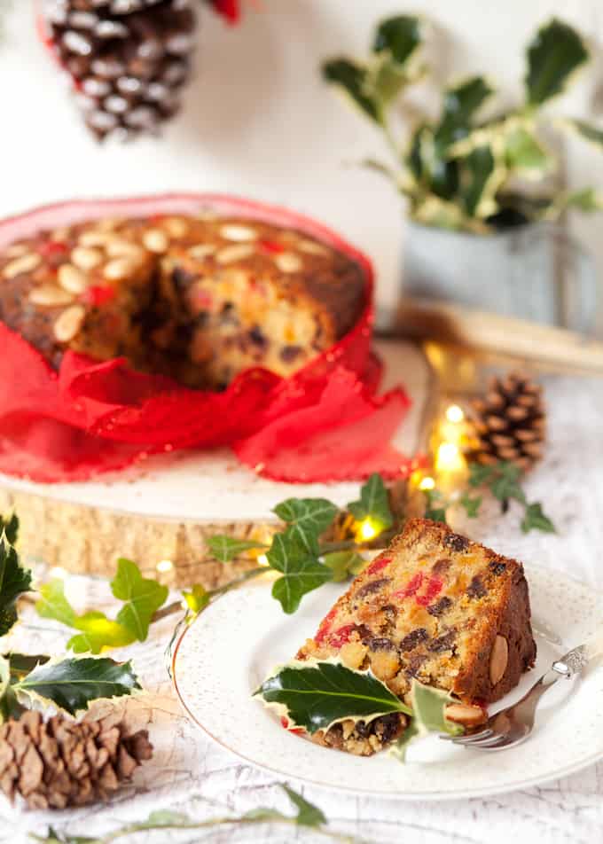 A slice of Last Minute Christmas Cake and the rest of the cake in the background