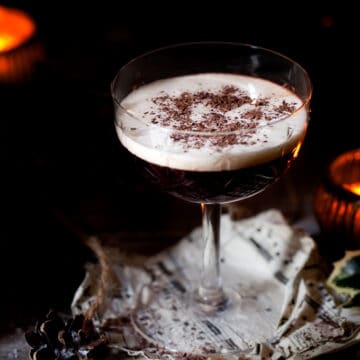 Chocolate and blackberry bourbon cocktail with a cream float and chocolate shavings