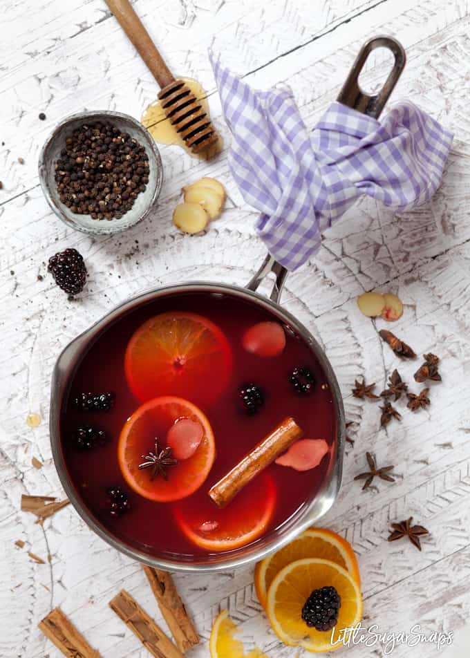 Mulled apple juice with blackberries - juice and ingredients in a pan