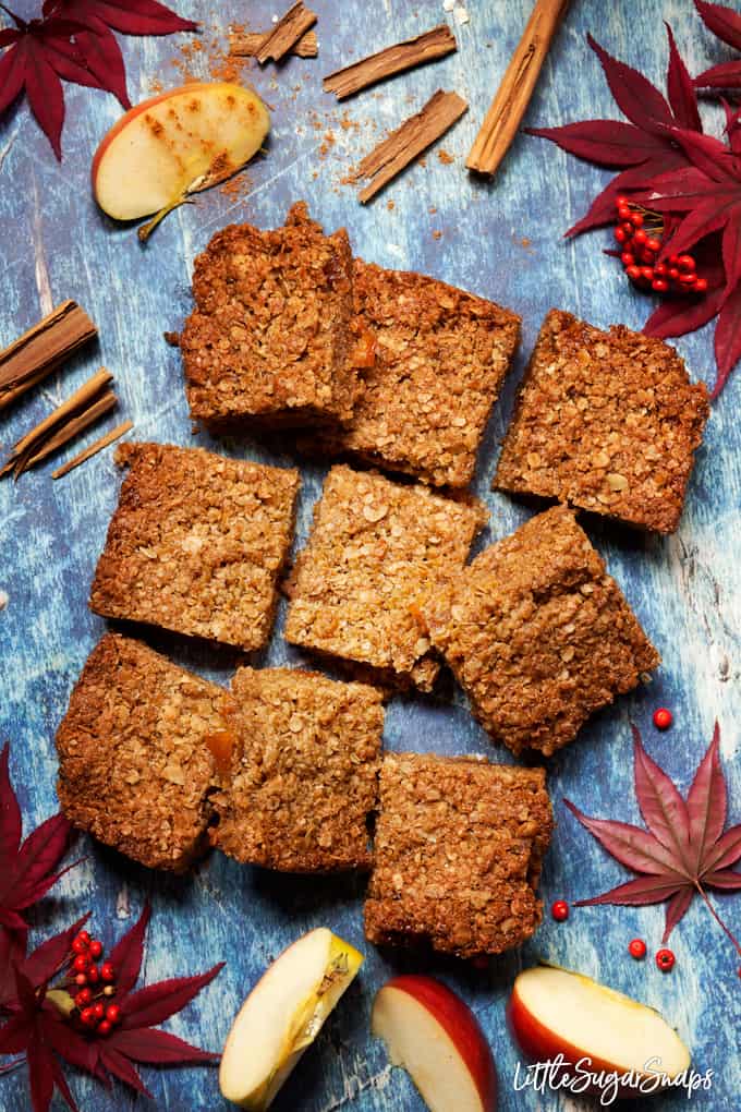 Oat bars filled with toffee apple sauce on a blue background, cut into squares