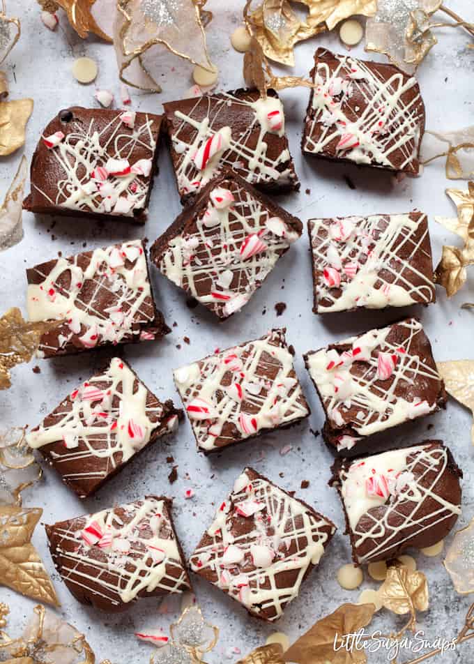 12 squares of candy cane brownies on a grey background.