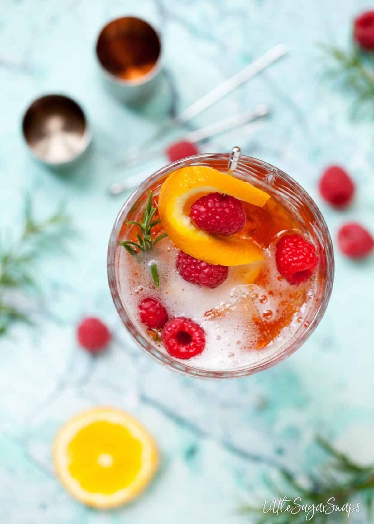 overhead view of a winter aperol spritz with sloe gin and rosemary