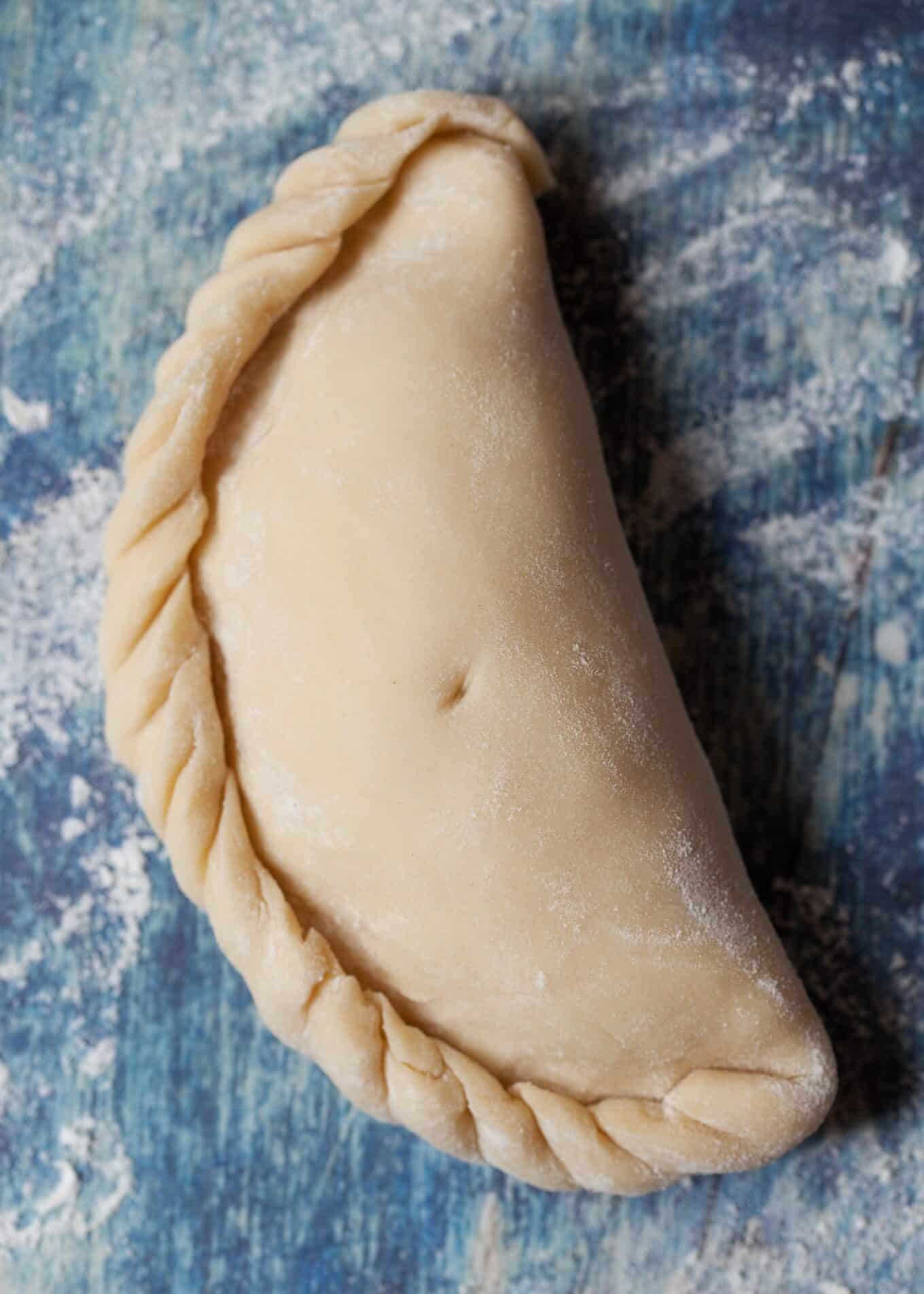 a crimped traditional Cornish pasty ready to bake