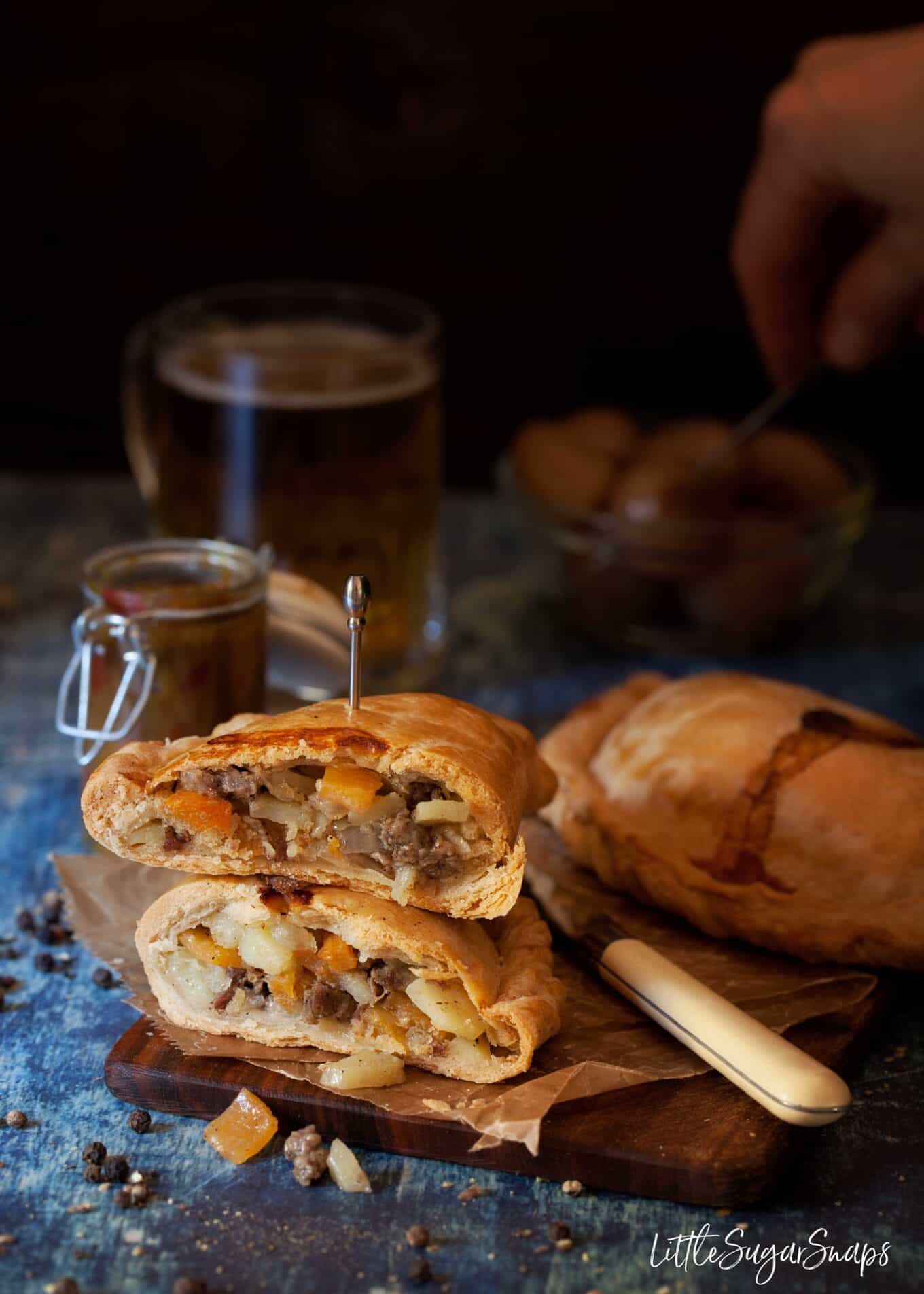 Beef pasties cut in half and stacked on top of each other to reveal the filling.