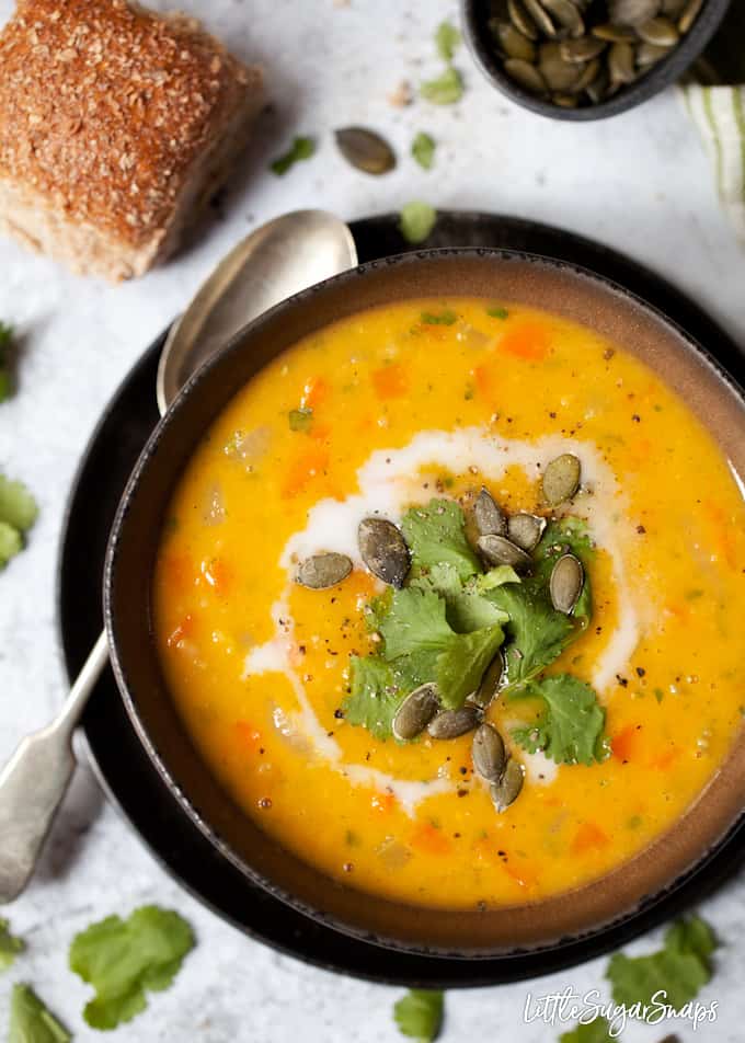 Carrot, lentil and coriander soup topped with pumpkin seeds.