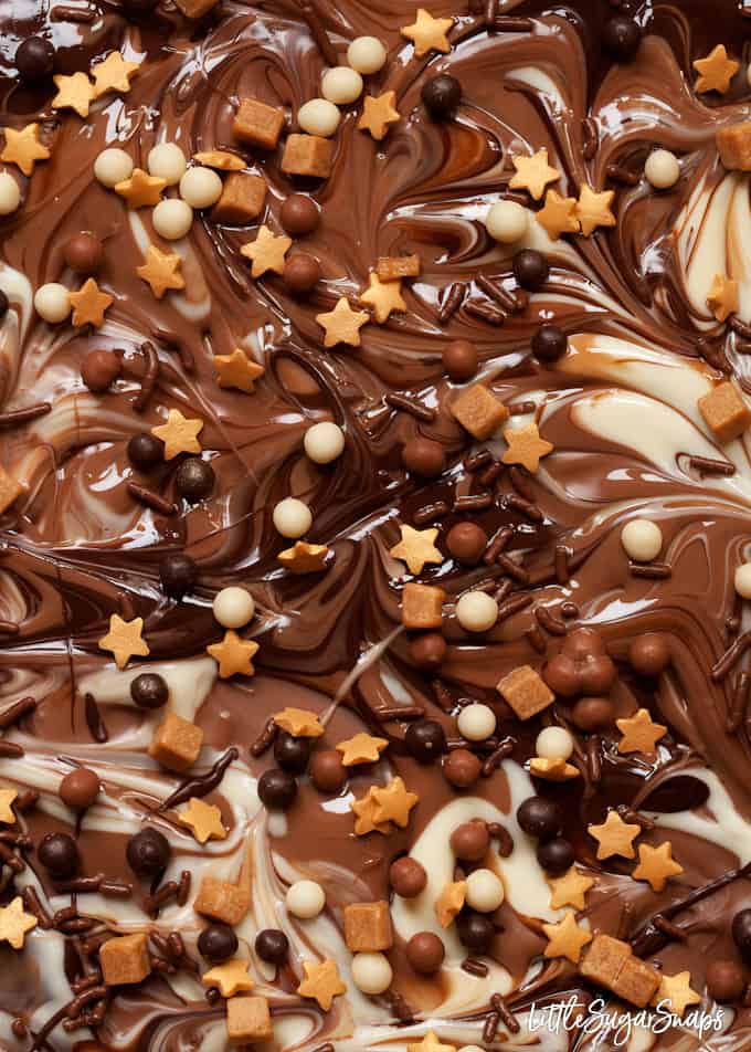 Close up of marbled chocolate with chocolate balls and gold star sprinkles.