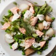 Salmon and Potato Salad with Horseradish Dressing with peas, lambs lettuce and dill served on a white place setting