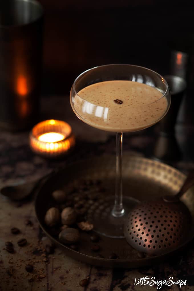 Creamy coffee cocktail in a tall glass. Garnished with a coffee bean and nutmeg