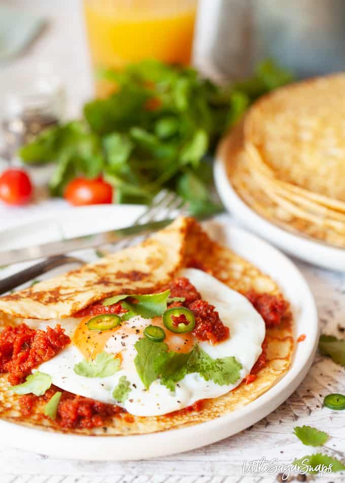 Huevos Rancheros cornmeal Crepes with spicy tomato sauce, a fried egg, green chillis and coriander.