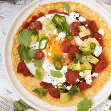 Huevos Rancheros with a cornmeal Crepe with spicy tomato sauce, a fried egg, green chillis and coriander plus chorizo, feta cheese and avocado chunks