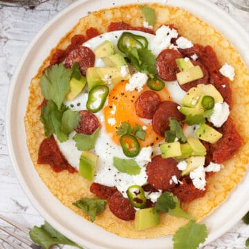 Huevos Rancheros with a cornmeal Crepe with spicy tomato sauce, a fried egg, green chillis and coriander plus chorizo, feta cheese and avocado chunks