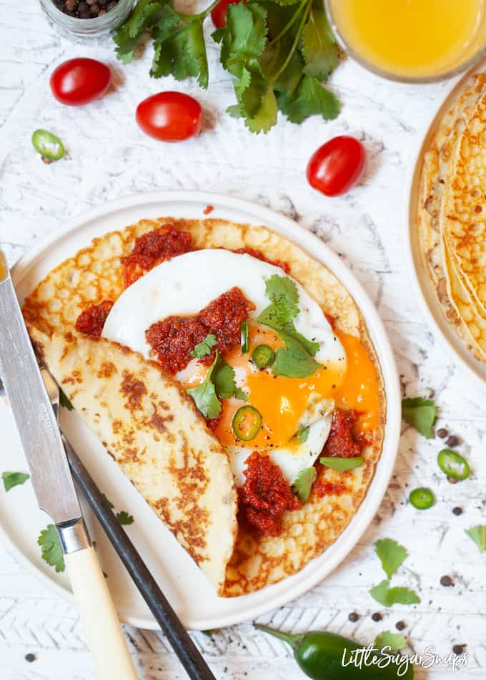 Huevos Rancheros cornmeal Crepes - with a fried egg, tomato sauce, green chilli and cilantro. 