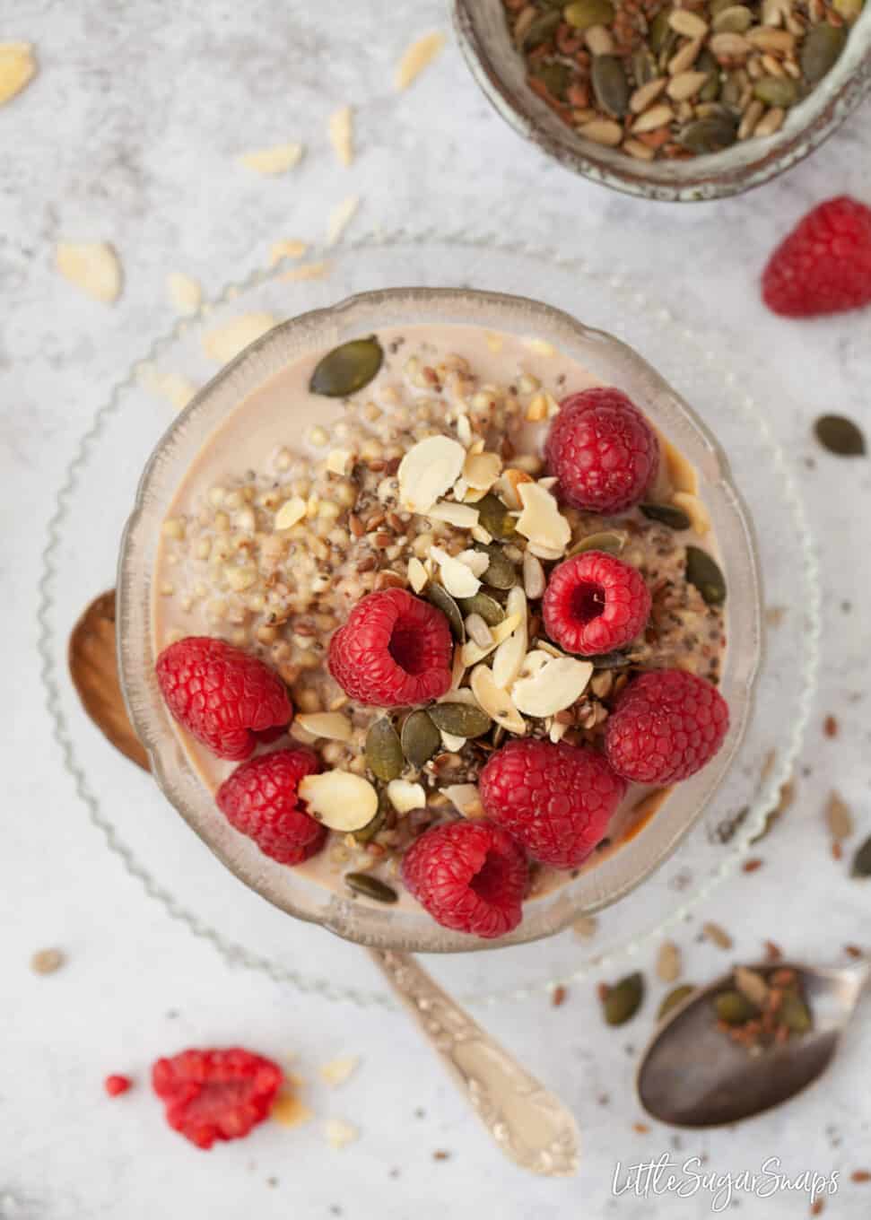 Spiced Buckwheat Porridge in a bowl with raspberries, pumpkin seeds and almond flakes