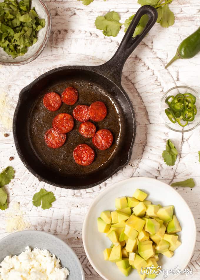 A few toppings for Huevos Rancheros crepes being prepared including avocado, green chilli, coriander, feta cheese and fried chorizo