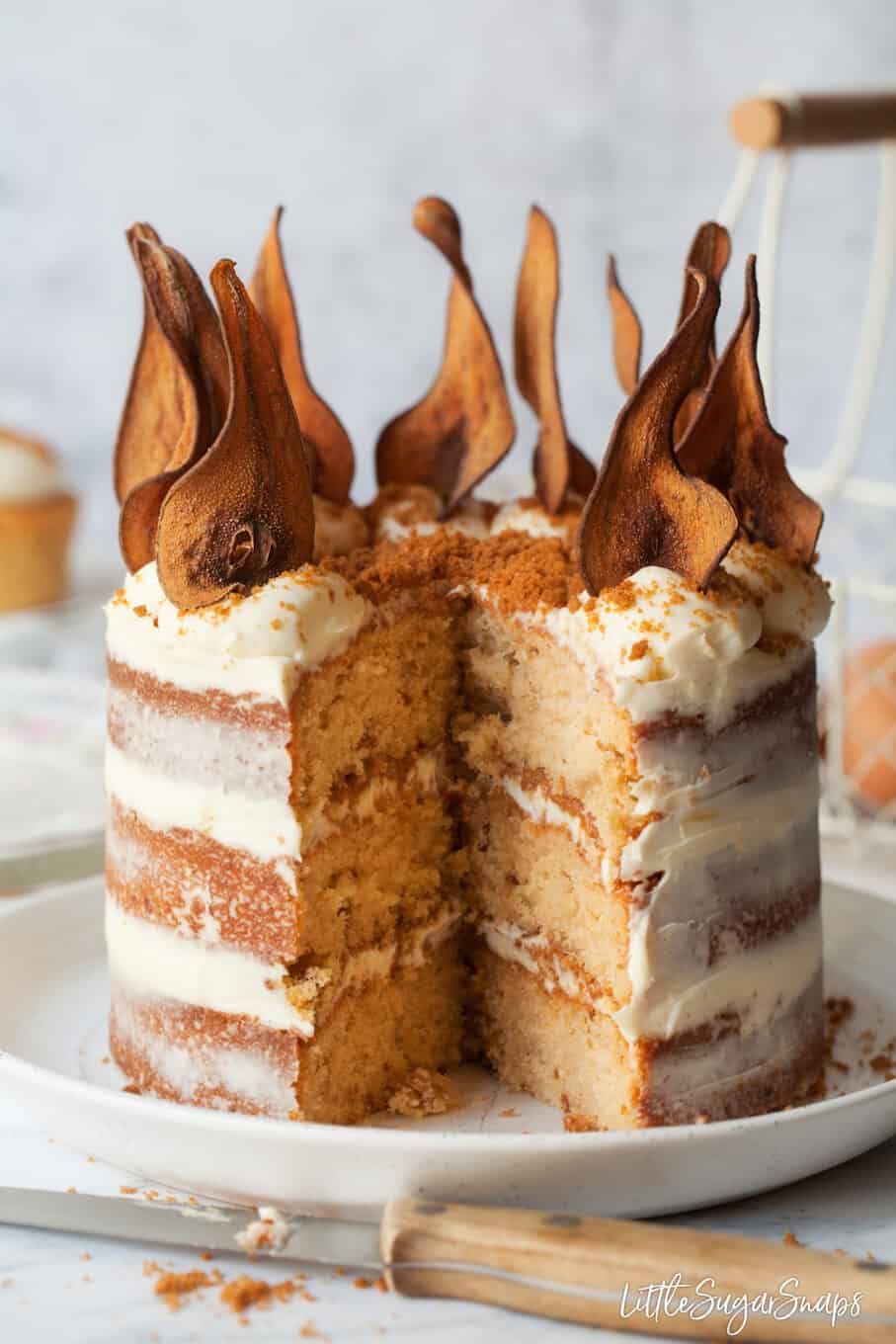 Pear cake recipe decorated naked style with dried pears on top and biscuit spread in the middle