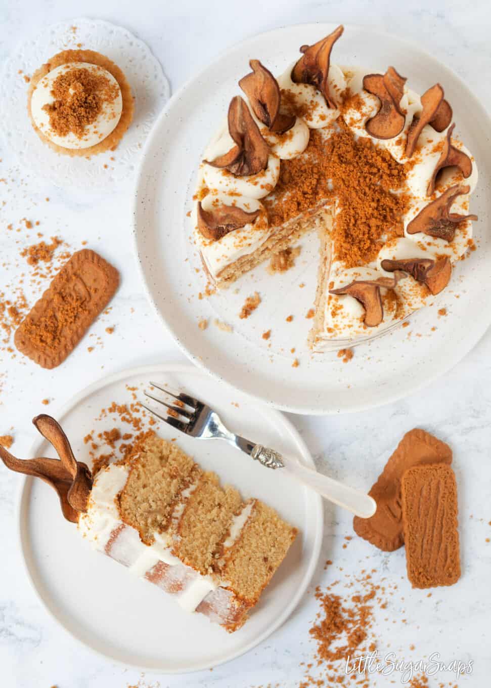 Top view of cut into pear cake recipe with mascarpone frosting, cookie crumbs and pear wafers
