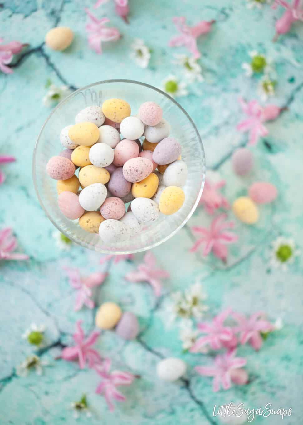 Chocolate mini eggs in a glass bowl.