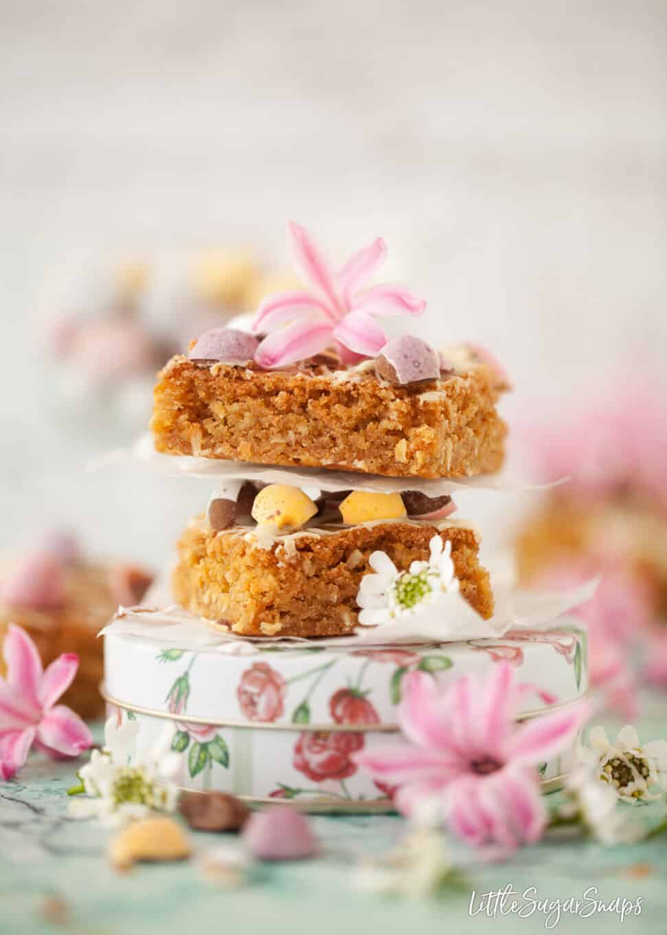 Two pieces of easter blondies with coconut stacked on top of each other.