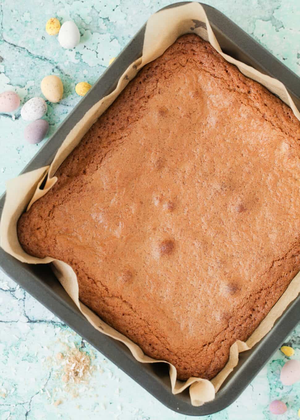 Process shot: freshly baked brown butter blondies with coconute in a tin