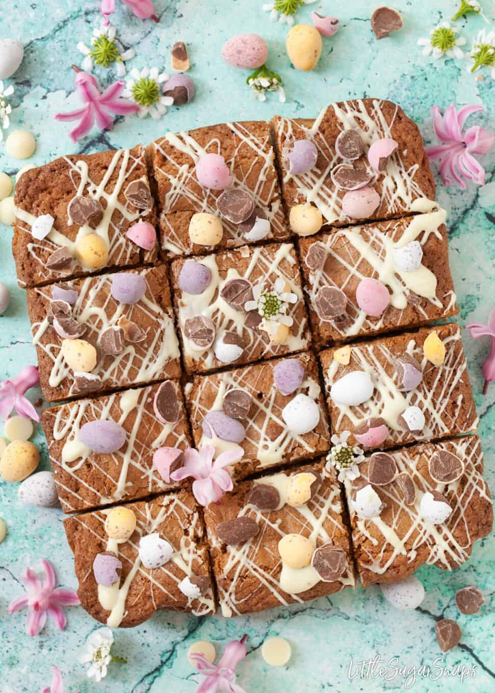 Squares of Brown butter blondies with chocolate drizzle and mini eggs.