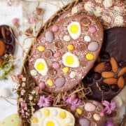 Homemade chocolate easter eggs decorated with fruit, nuts, jelly sweets and mini eggs