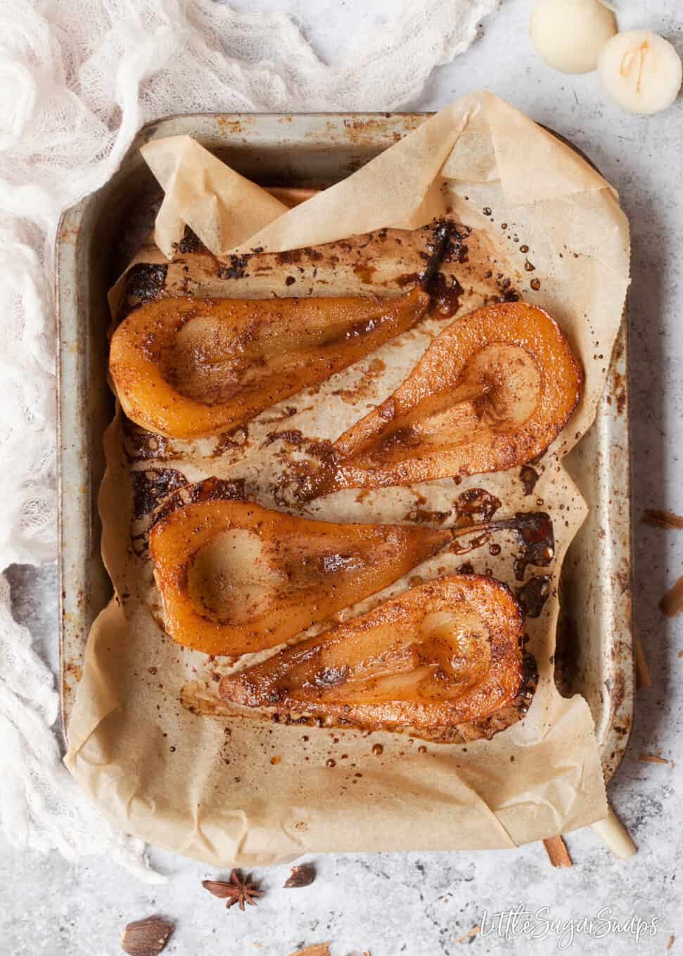 chai spiced pears on parchment in a roadting tin