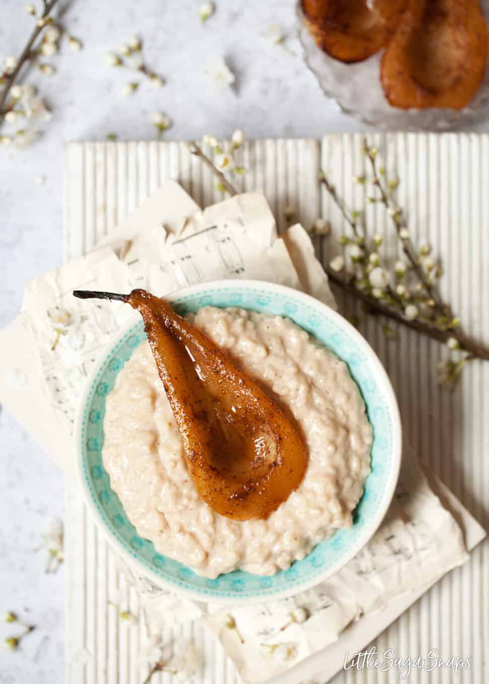 Vegan rice pudding and spiced pear in a blue bowl.