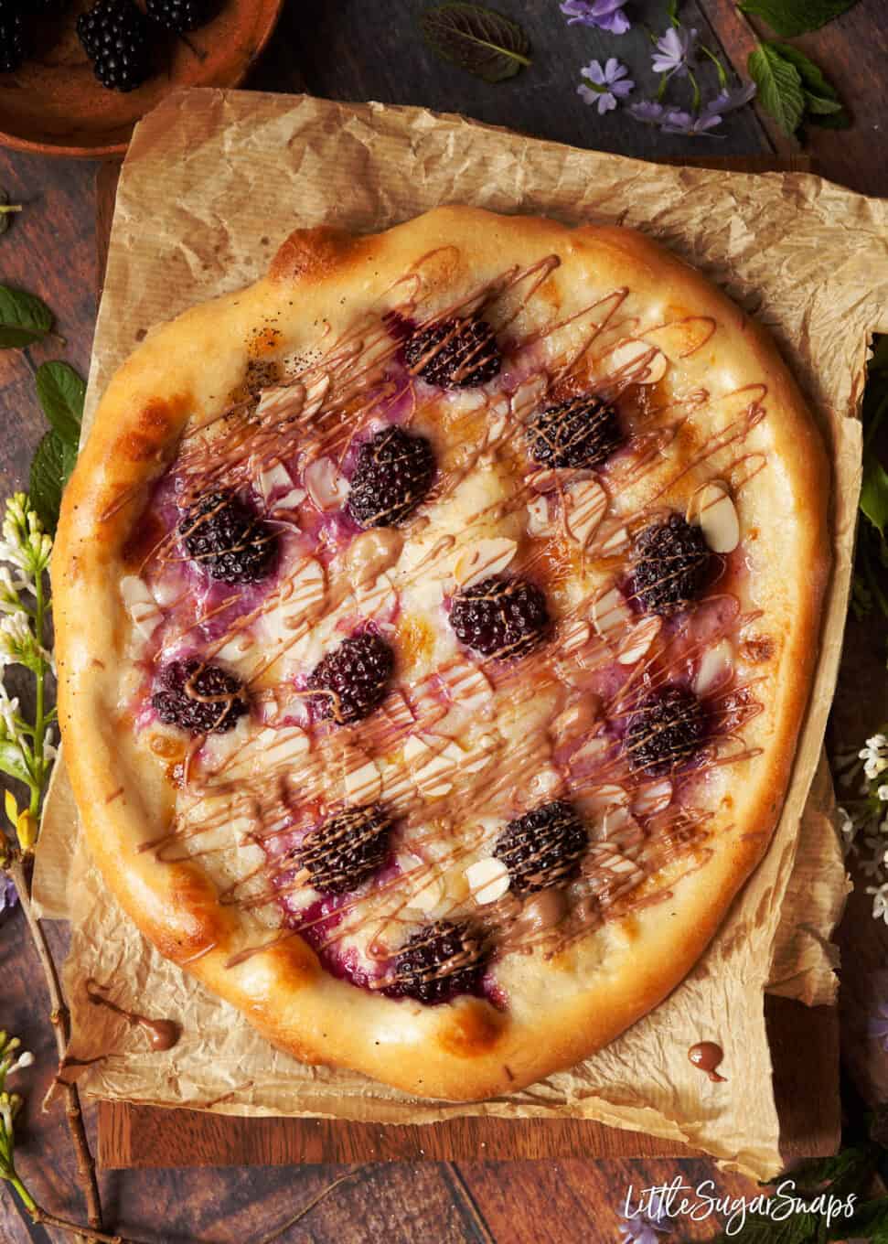 process shot: adding chocolate drizzle to pizza base of mascarpone and roast fruit