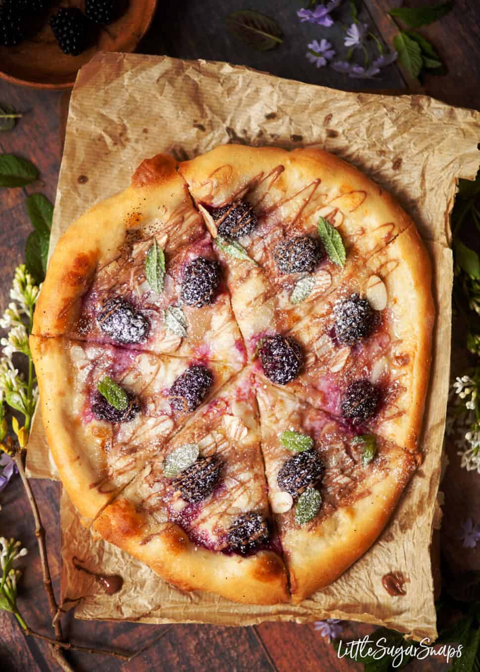 Sweet pizza with mascarpone and roast berries sliced into triangles.