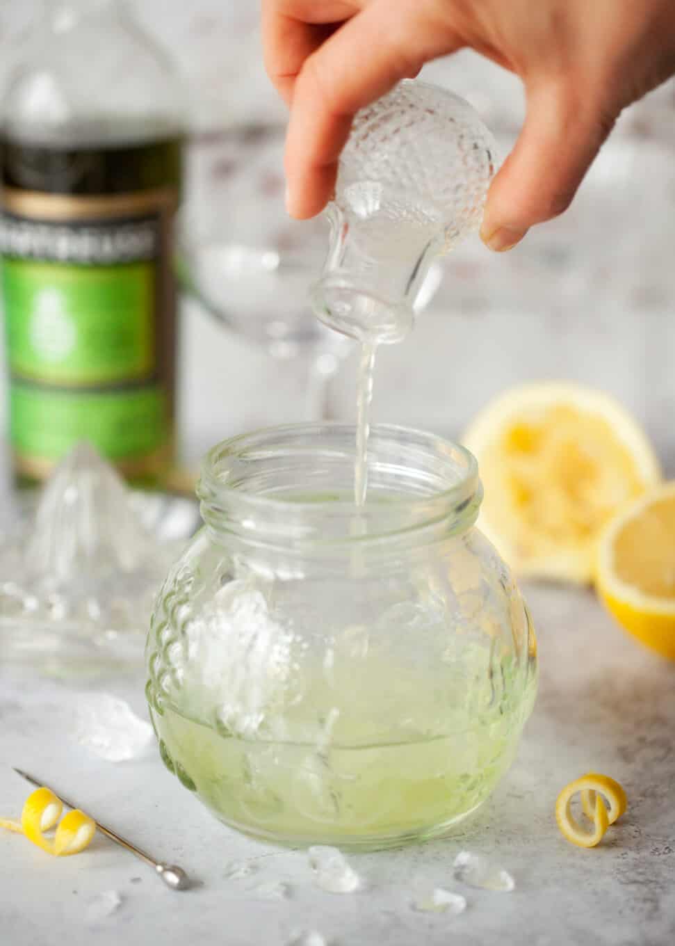 Pouring ingredients for a gin & green chartreuse Spring feeling cocktail.