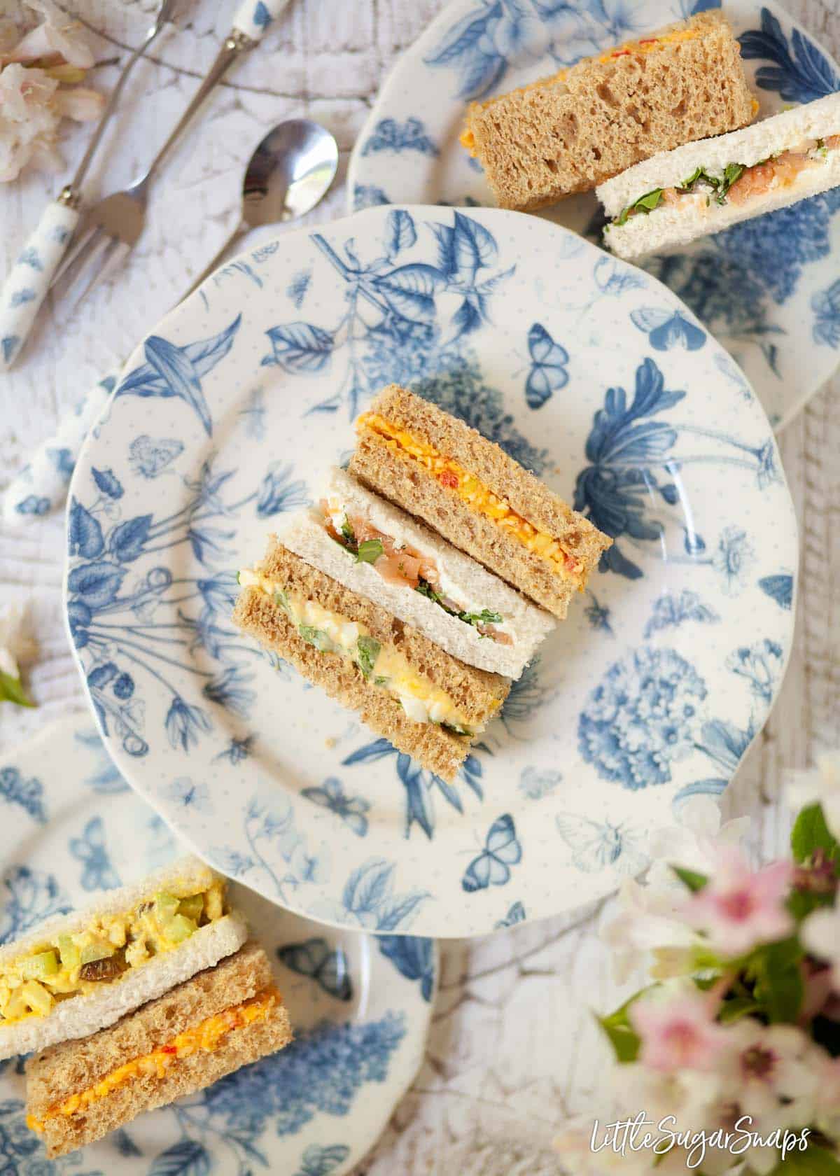 Mixed afternoon tea sandwiches served on blue and white crockery. 