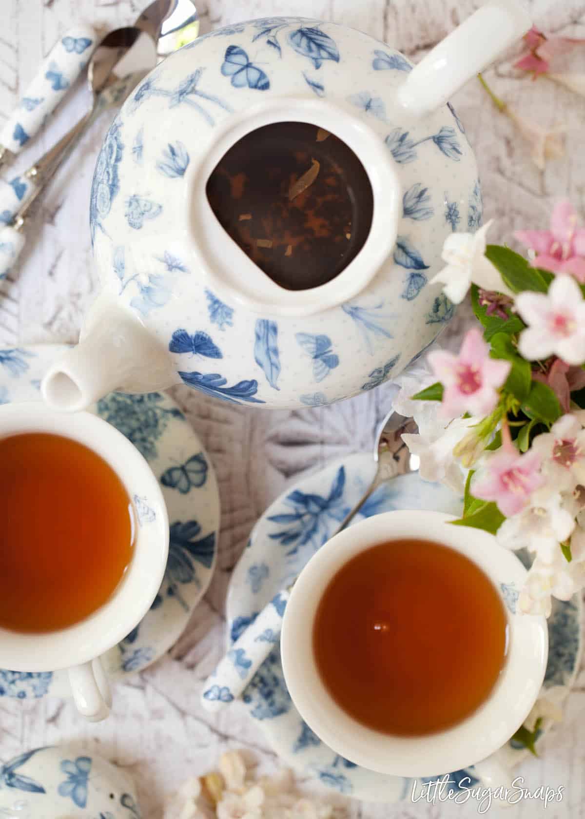 A butterfly print teapot with the lid off to reveal the tea steeping inside 