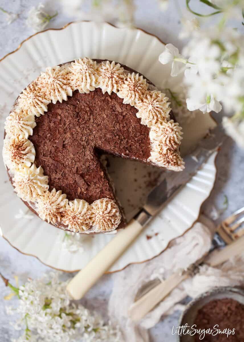 Overhead view of a chocolate cake with a slice removed. 