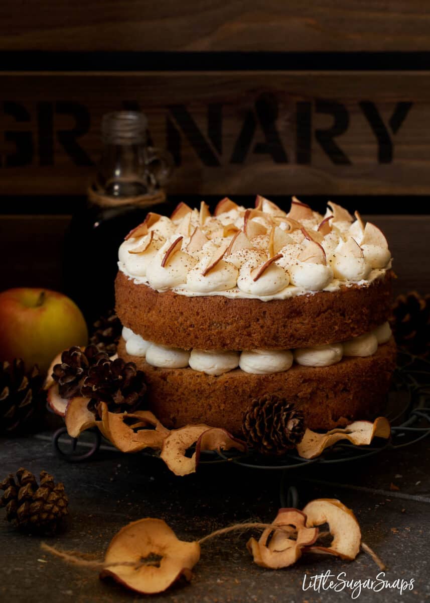 A cinnamon apple sponge cake sandwiched with buttercream and topped with dried apple.